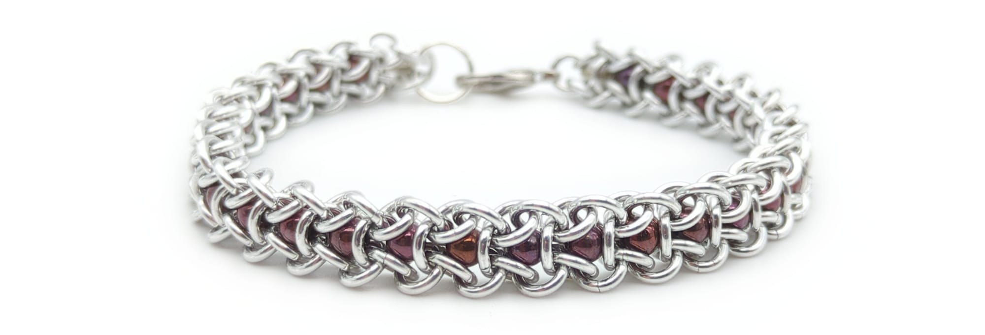 A much thinner bracelet made of a single row of hexagons, with beads captured in the center of each one.