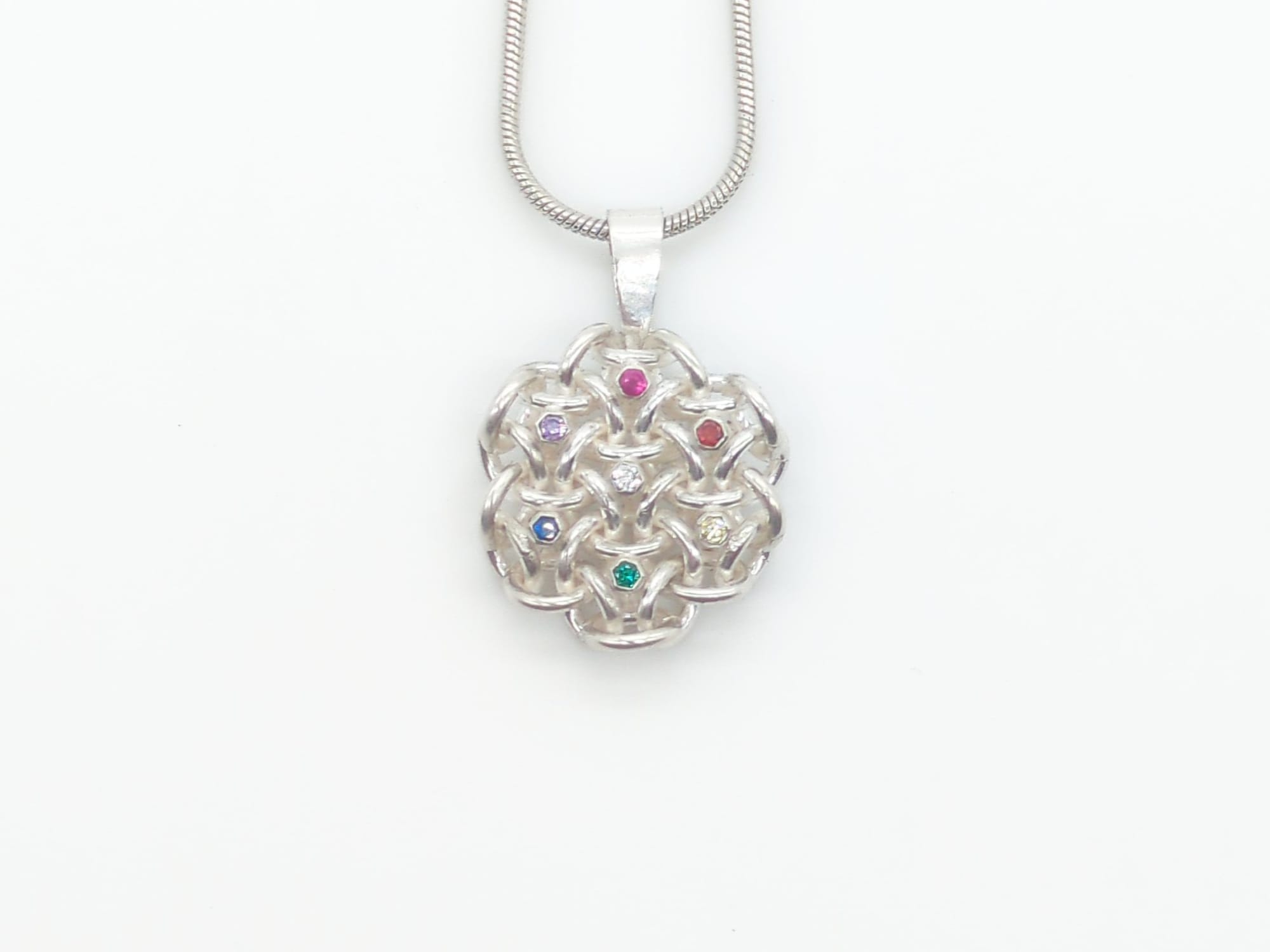 A pendant with 7 tube-set gemstones, one for each hexagon.