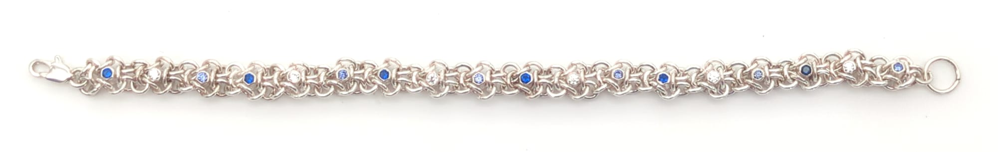 A thin single-row bracelet with tube-set gemstones in every other hexagon.