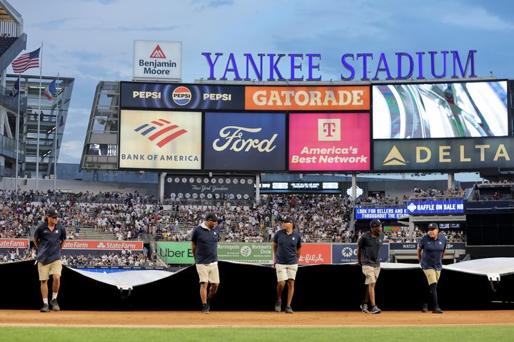 embers of the grounds crew put the tarp on the field during a rain delay during the third inning between the New York Yankees