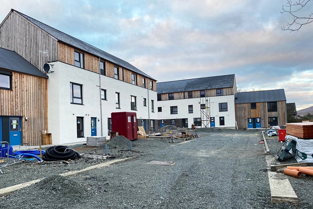 New timber-clad terraced homes for affordable rent nearing completion on a building site in Portree, Skye