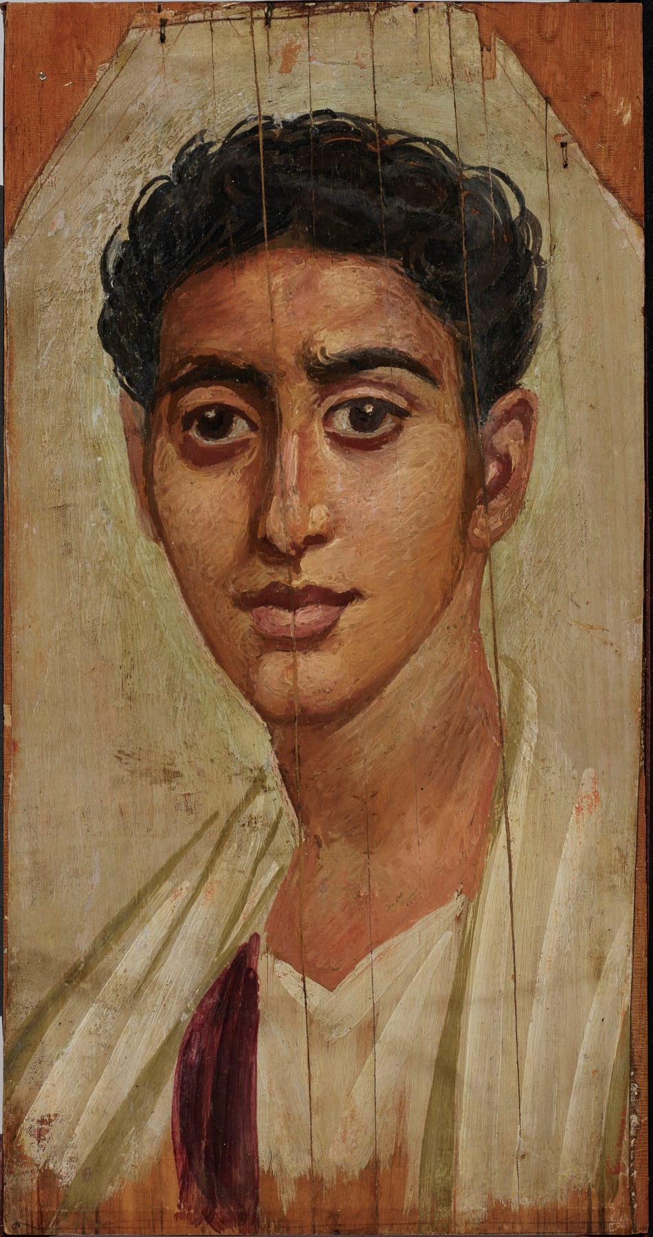 portrait of a brown-skinned man with a long oval face, dark hair, and big soulful eyes