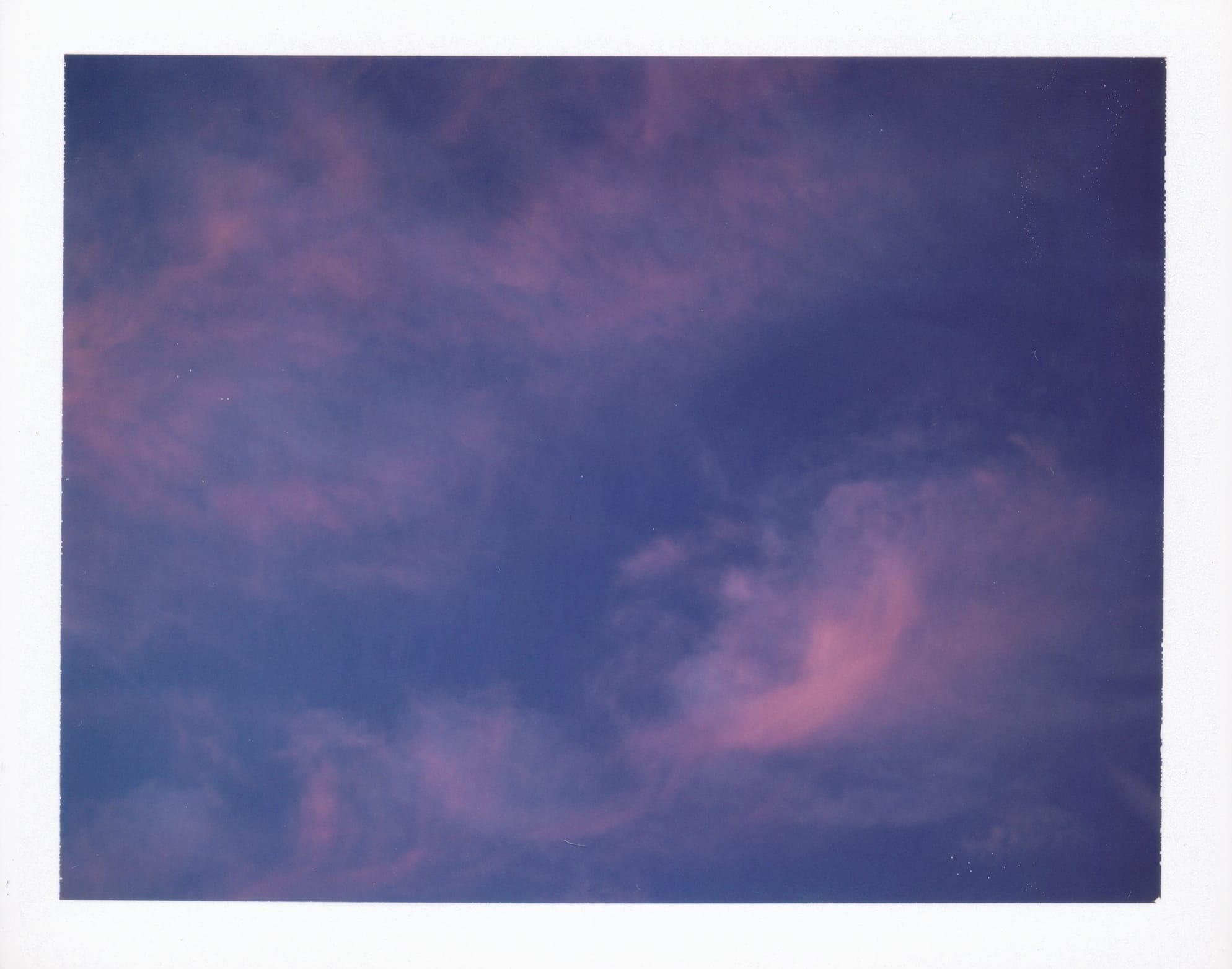 A dark blue sky with wisps of pink clouds filling the frame