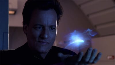 Character Q from Star Trek: The Next Generation, his hand palm up, appearing to hold a nebulous, wispy light source