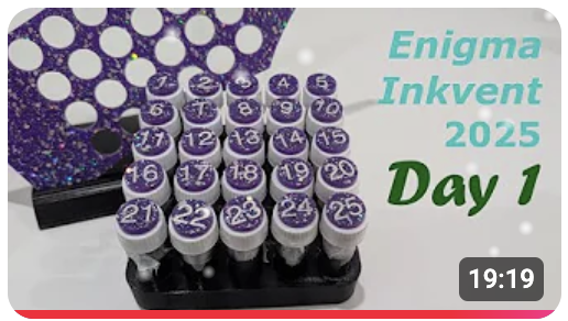YouTube thumbnail showing a grid of 25 ink sample vials in a holder with a title "Enigma Inkvent 2025 Day 1"