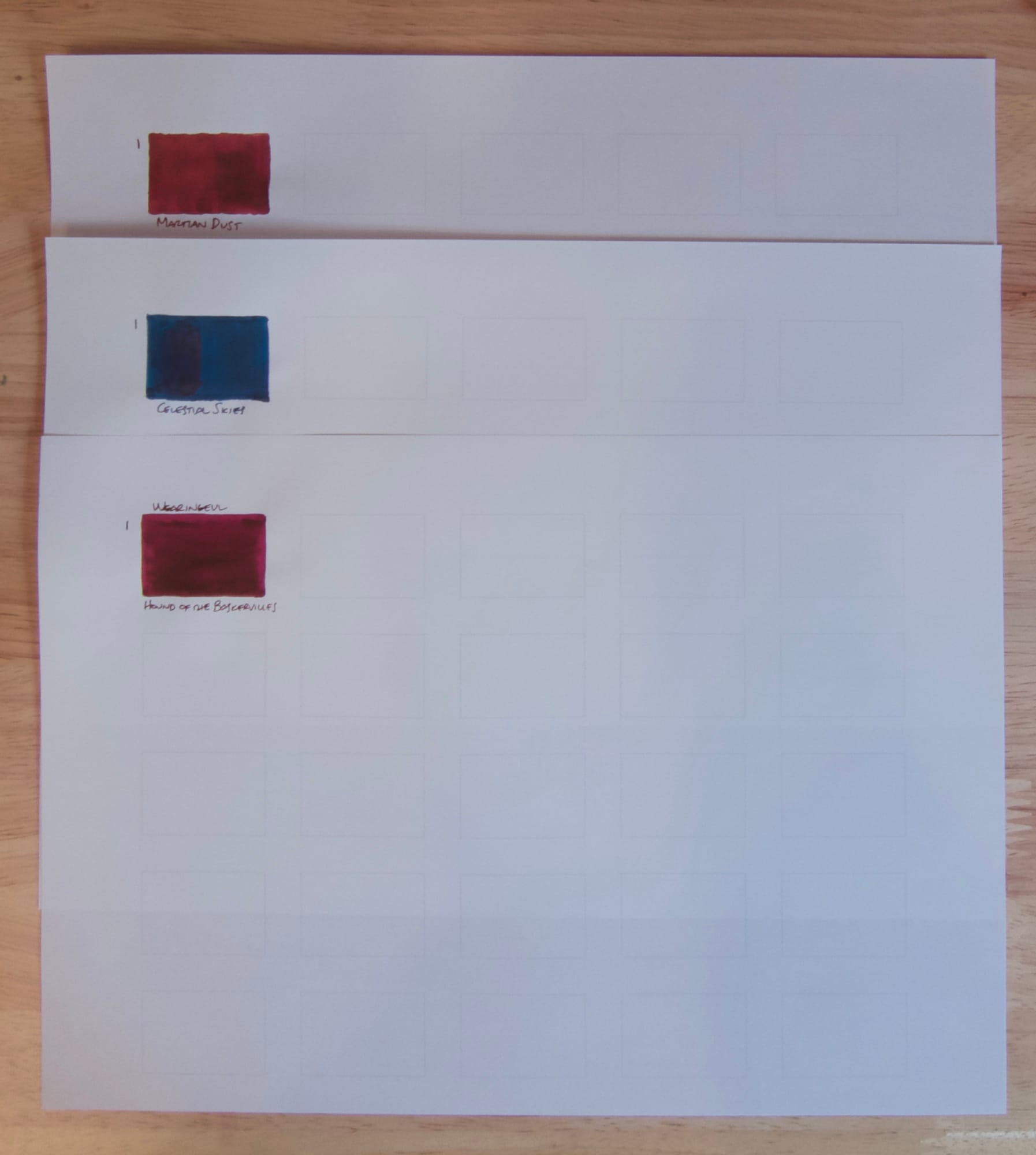 3 A4 sheets of paper with a 5x5 grid of rectangles in a calendar-type layout, the first rectangles of each sheet filled in with ink swatches