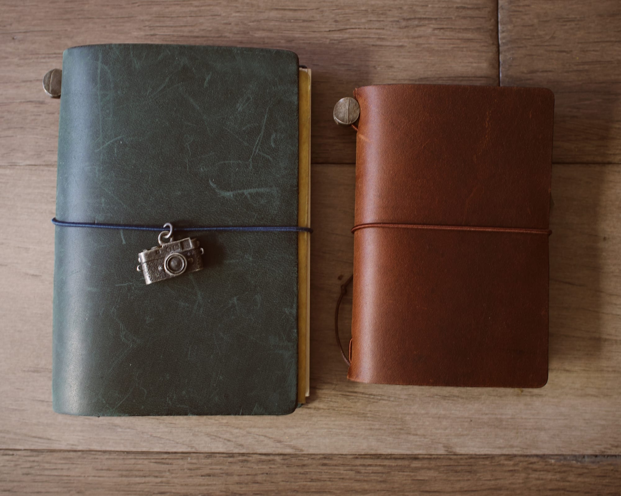 Left: blue, passport-sized Traveler's Company notebook, right: brown, credit-card sized Traveler's Company notebook