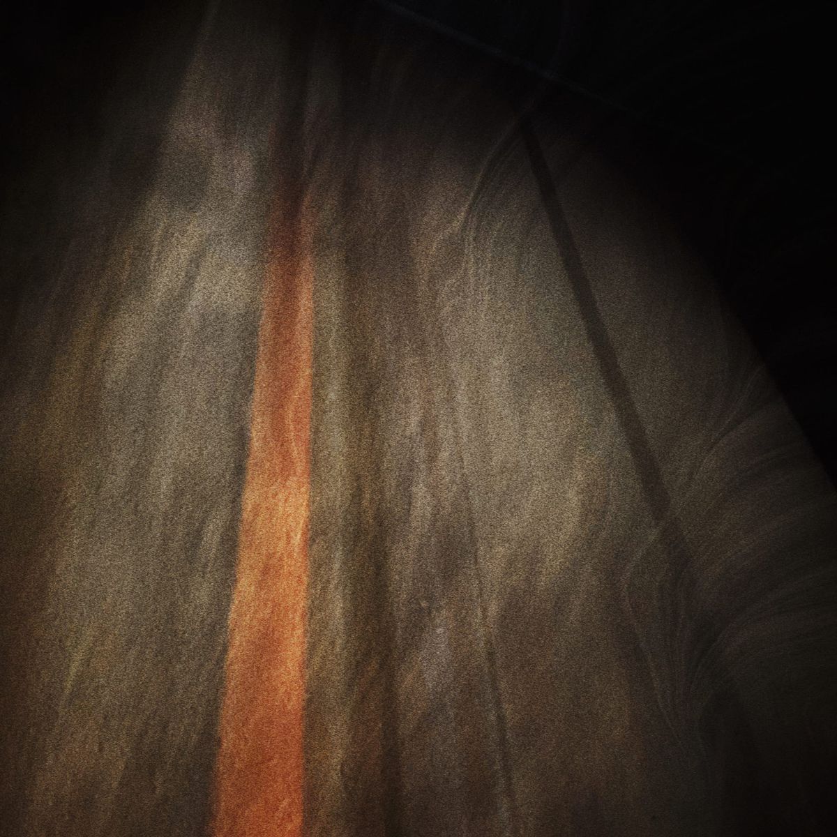 Warm gray and golden brown stripes and lines converging out of frame with an overlay of wavy texture