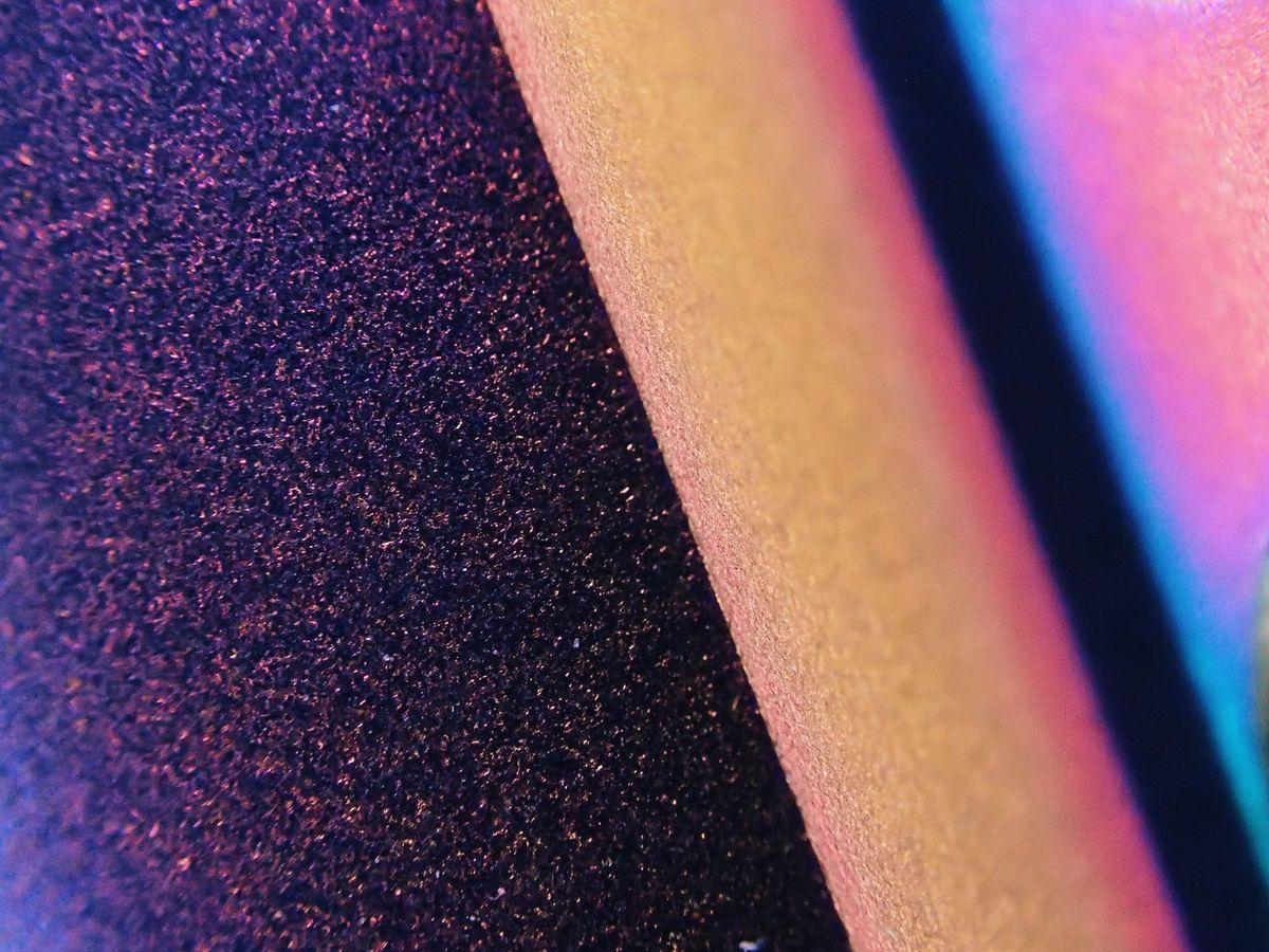 Abstract macro of textured titanium metal with rainbow gradient of colors