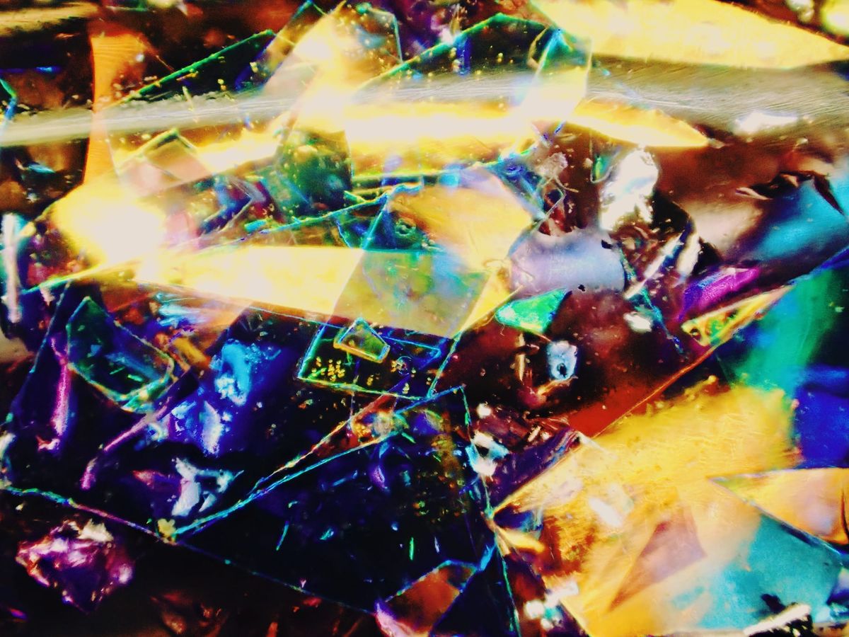 Extreme macro of chunky, multicolored and holographic glitter suspended in transparent resin