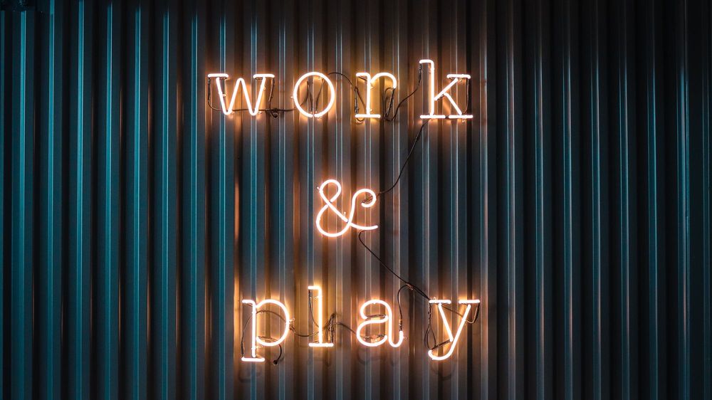 A neon sign, saying "work and play"