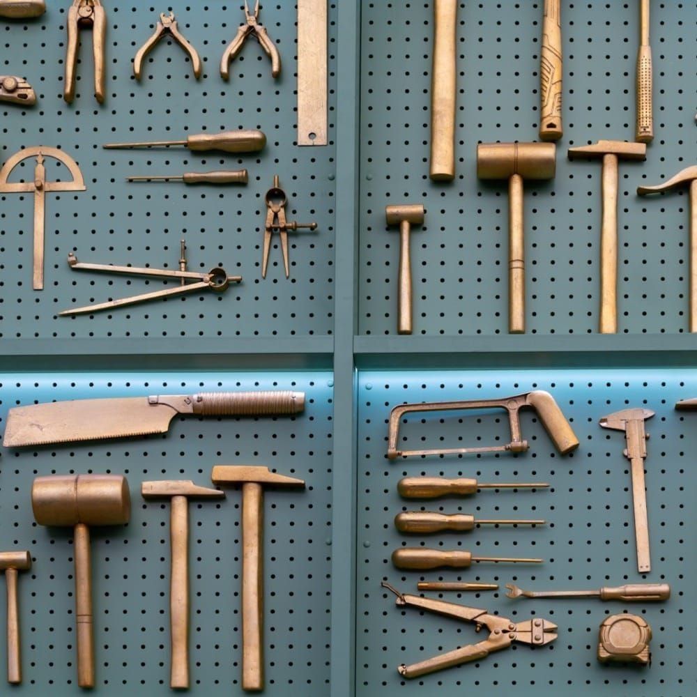 A bunch of tools on a tool board. All have been spraypainted gold.