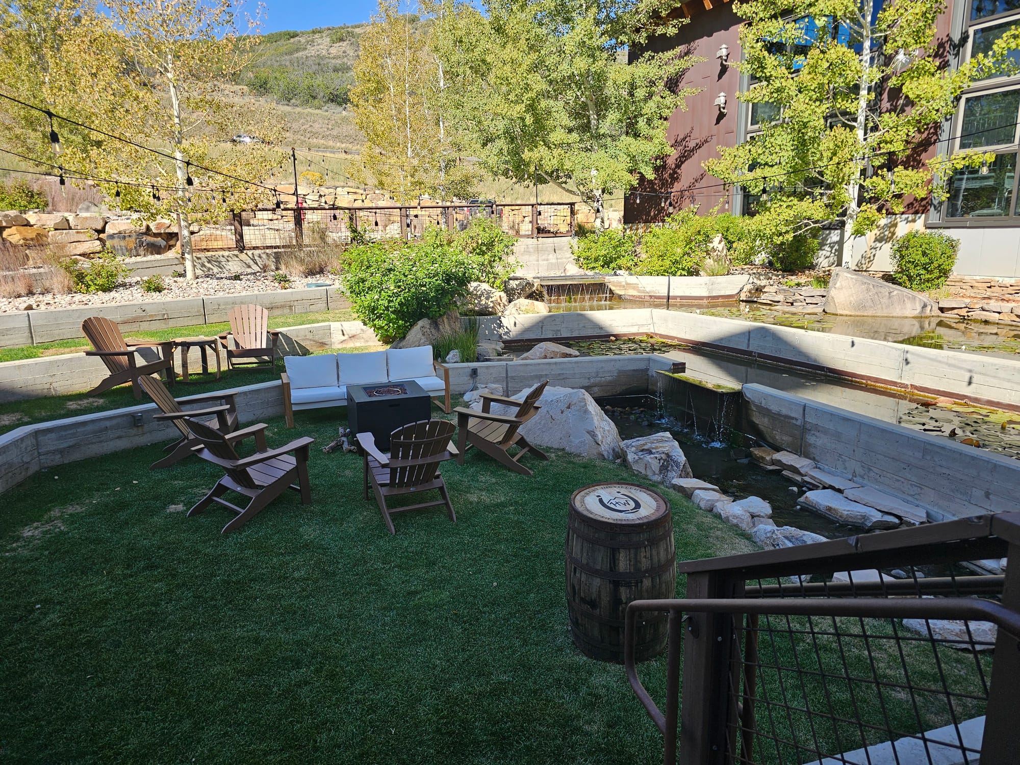 Outdoor seating and a fire pit surrounded by trees at High West Distillery