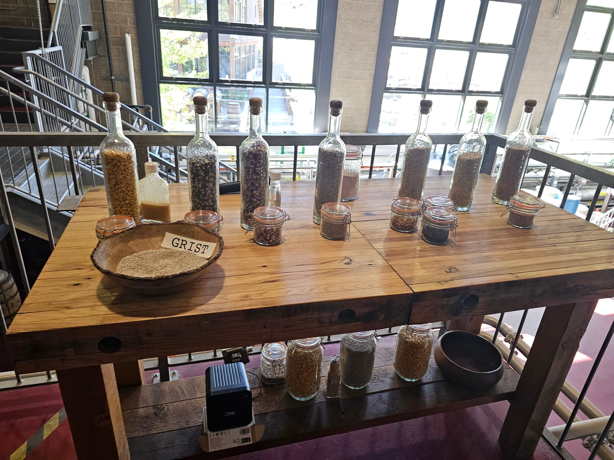 Bottles of grain samples displayed on a wooden table at High West