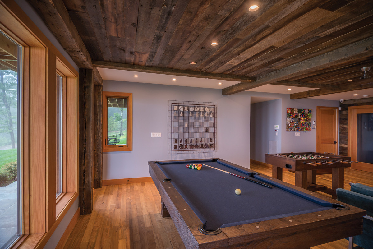 The game room has a more masculine feel than the rest of the home, featuring darker stained timbers and reclaimed ceiling paneling from Pioneer Millworks.