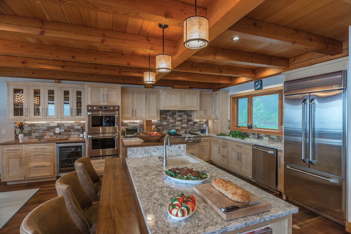 The home&rsquo;s kitchen is tailormade to the needs of the owners, featuring custom ash and walnut cabinets and woodwork by NEWwoodworks and reclaimed wood wall paneling from Pioneer Millworks.