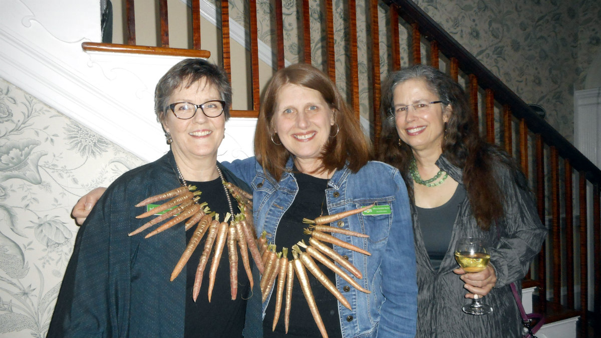 Berkshire Grown Executive Director Margaret Moulton and Board President&nbsp;Allison Rachele Bayles model the 14-carat carrots beside Cynthia Pansing of Berkshire Agricultural Ventures.