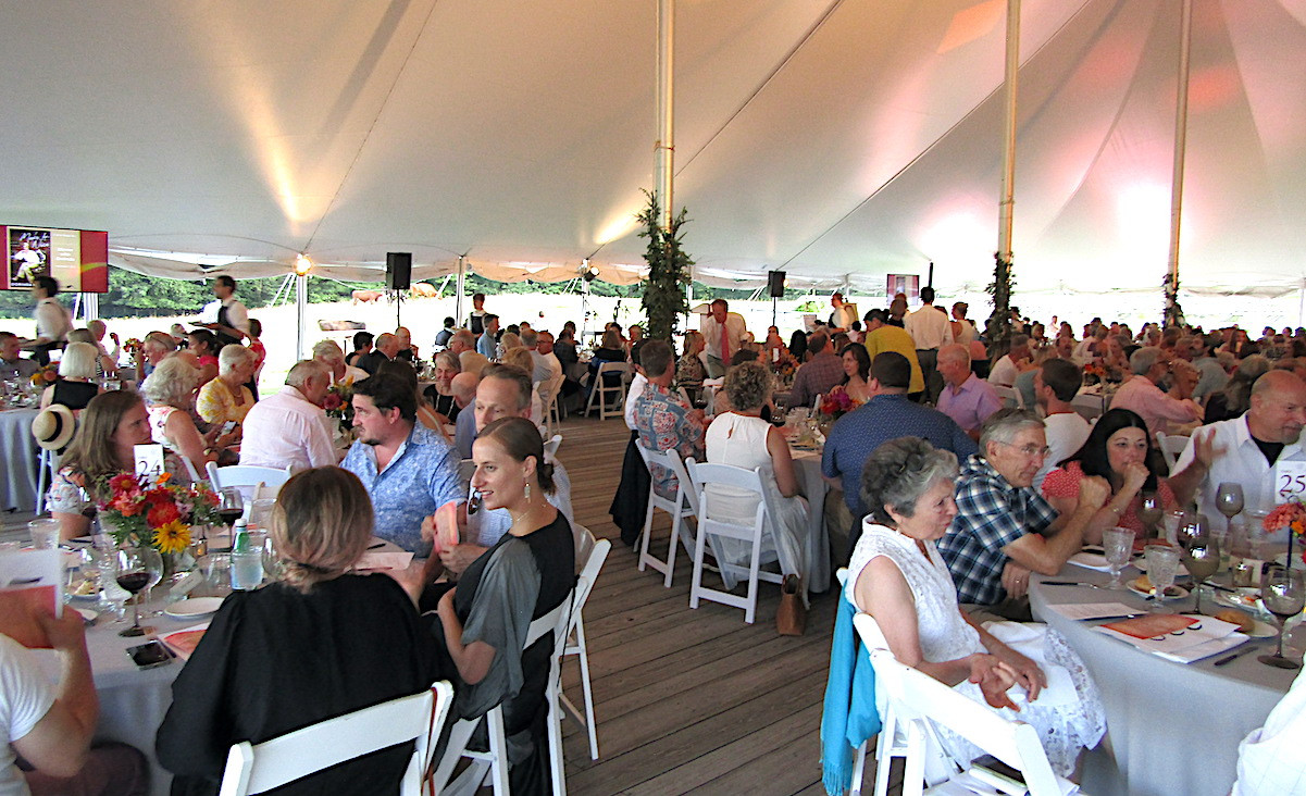 Gala guests enjoy dinner, prepared by Mezze Catering, under the tent on the Hancock Shaker Village grounds