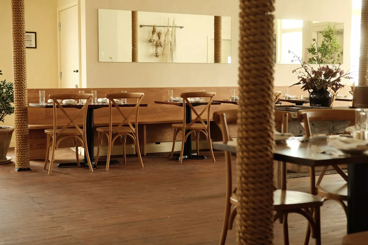 With just 44 seats, the dining room offers space to breathe. Blonde wood tables and syrup-colored floors keep things warm within the minimalist, farmhouse-chic setting. - Isabela