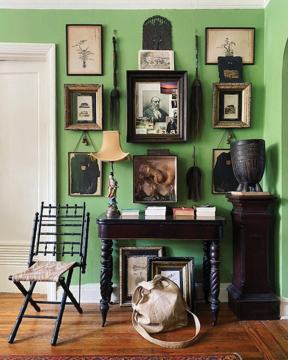 The arsenic green walls in Coviello&rsquo;s Brooklyn Heights apartment are a custom color designed by him. The gallery wall features antique objects and ephemera collected from flea markets and antique shops across the world from China to Peru.