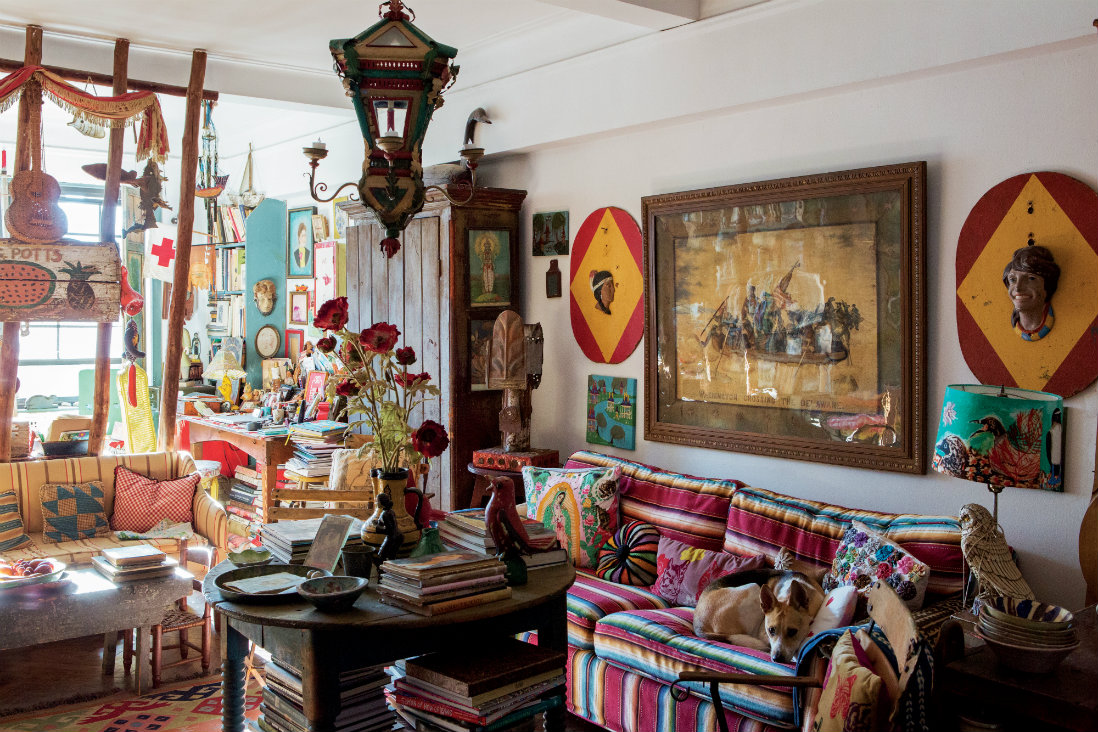 How Mary Randolph Carter lives: "In our living room, the trap stake partition divides the sitting and work areas. The serape-covered sofa is camouflaged with a collection of pillows and our grand-dog Cora. A pair of 3-D carnival plaques flank an embroidered interpretation of Washington Crossing the Delaware inspired by Emanuel Leutze's famous painting."