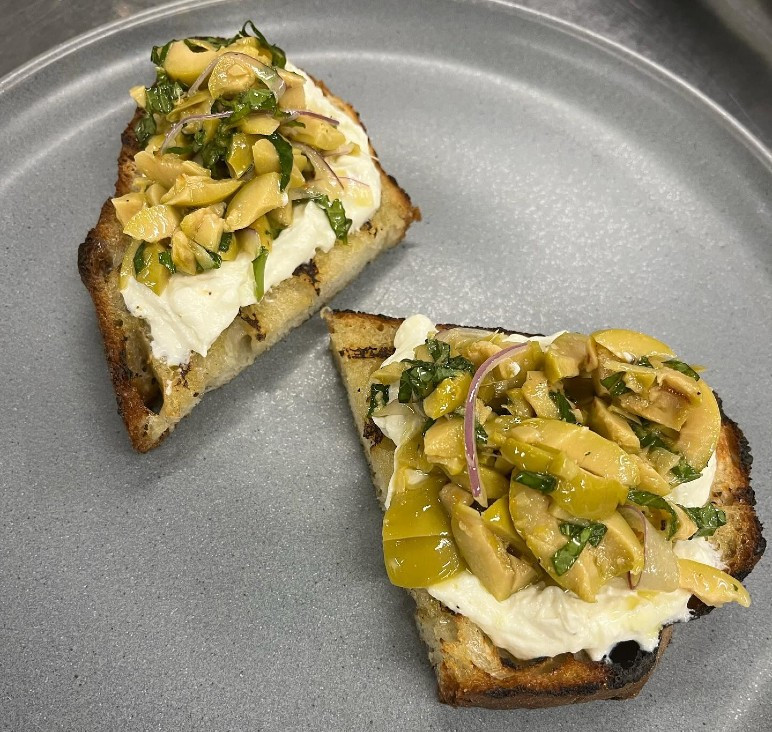 Green olive and ricotta crostini, from the Cichetti menu Green olive and ricotta crostini, from the Cichetti menu