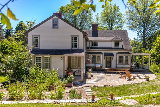 A rear view of the Reisfeld home, formerly the Elling&rsquo;s Guest House. The Reisfelds worked with Stephen Fitch of Fitch Landscaping and Jesse Bunce of Bunce Property Services to transform an overgrown lawn space that had been plagued by invasive species into an inviting backyard and patio space. They chose pea gravel to surround the fire pit and raised-bed gardens, and created walkways out of stone salvaged from a former patio. Fitch also helped rebuild the property&rsquo;s original stone retaining wall.

All photos by Winona Barton-Ballentine