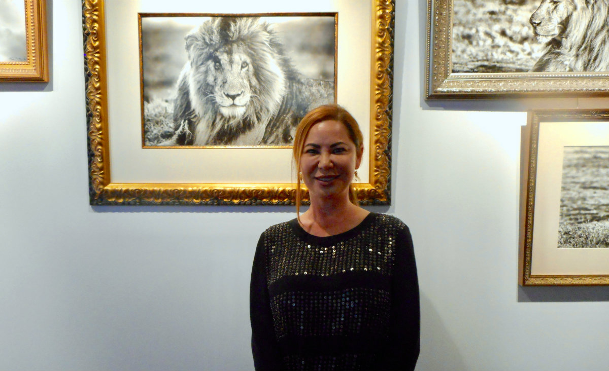 ROAM Gallery&rsquo;s&nbsp;Xtina Gegan Parks&nbsp;in front of her photographs.]
