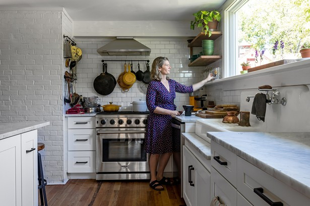 Kathy Reisfeld in the home&rsquo;s new kitchen, which had been badly damaged by flooding before the couple bought the home. With the help of architect Inma Donaire, they reimagined the space to include a modern rectangular window capturing the arboreal view. &ldquo;The home feels like it has its own life to it,&rdquo; explains Reisfeld. &ldquo;It feels like we are just custodians of this place for a while.&rdquo;