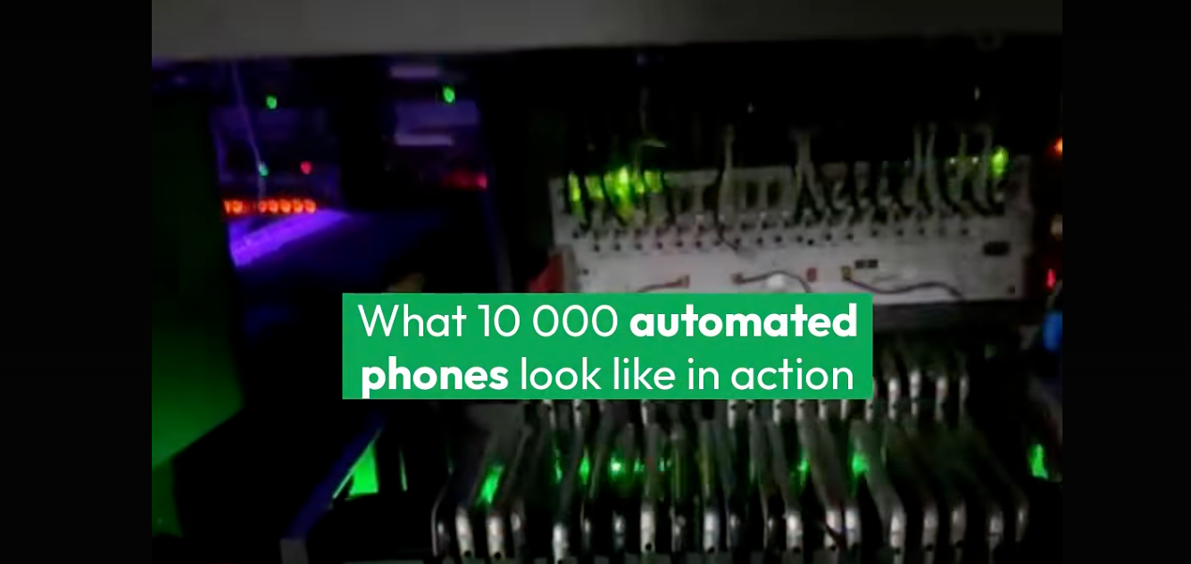 A phone farm: racks of automated phones running fake accounts at scale.