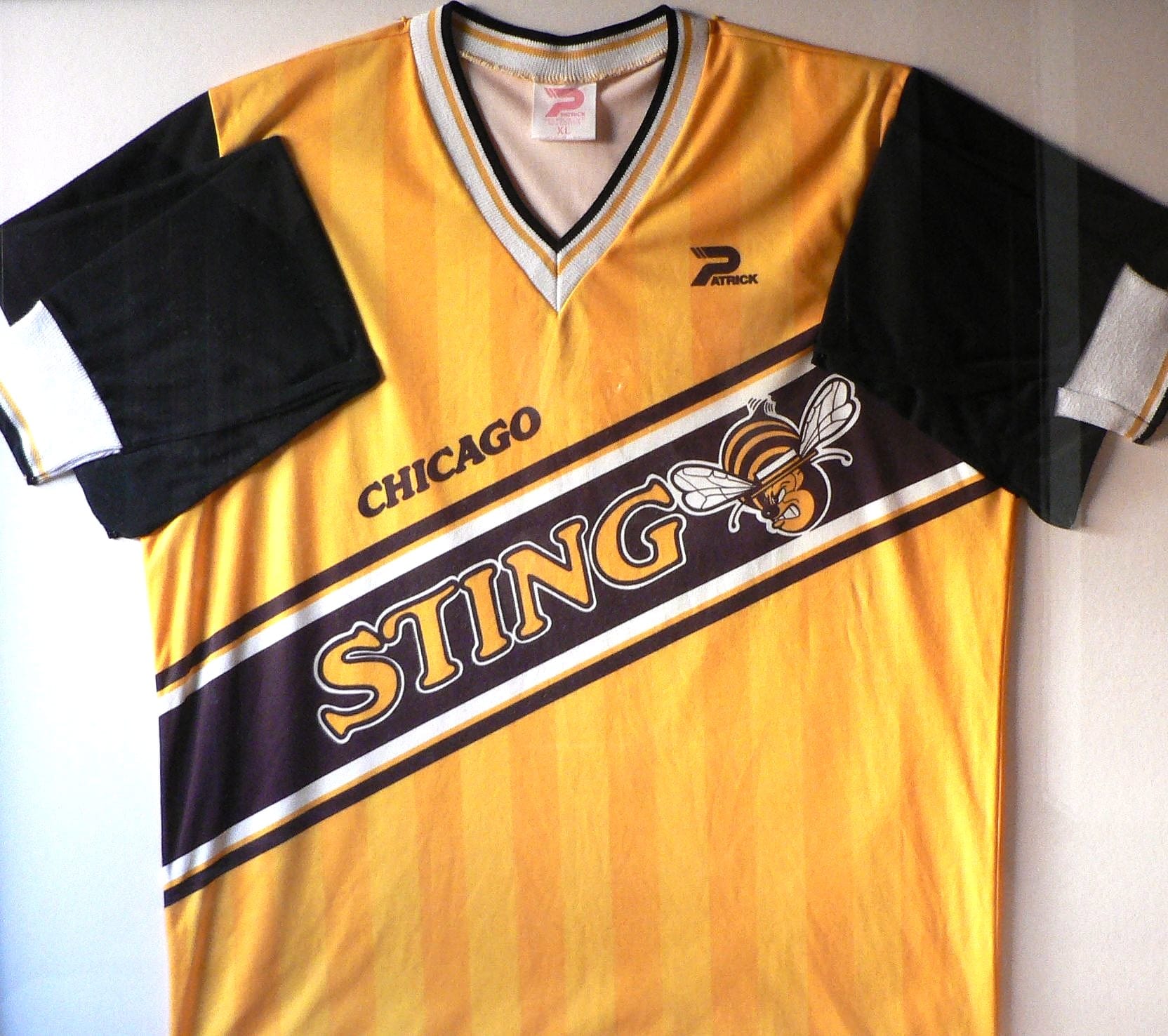 Shot of a Chicago Sting jersey, yellow with a bee and 'Sting' on it, from their MISL era. Photo by Ralph Morris, CC BY-SA 2.0 