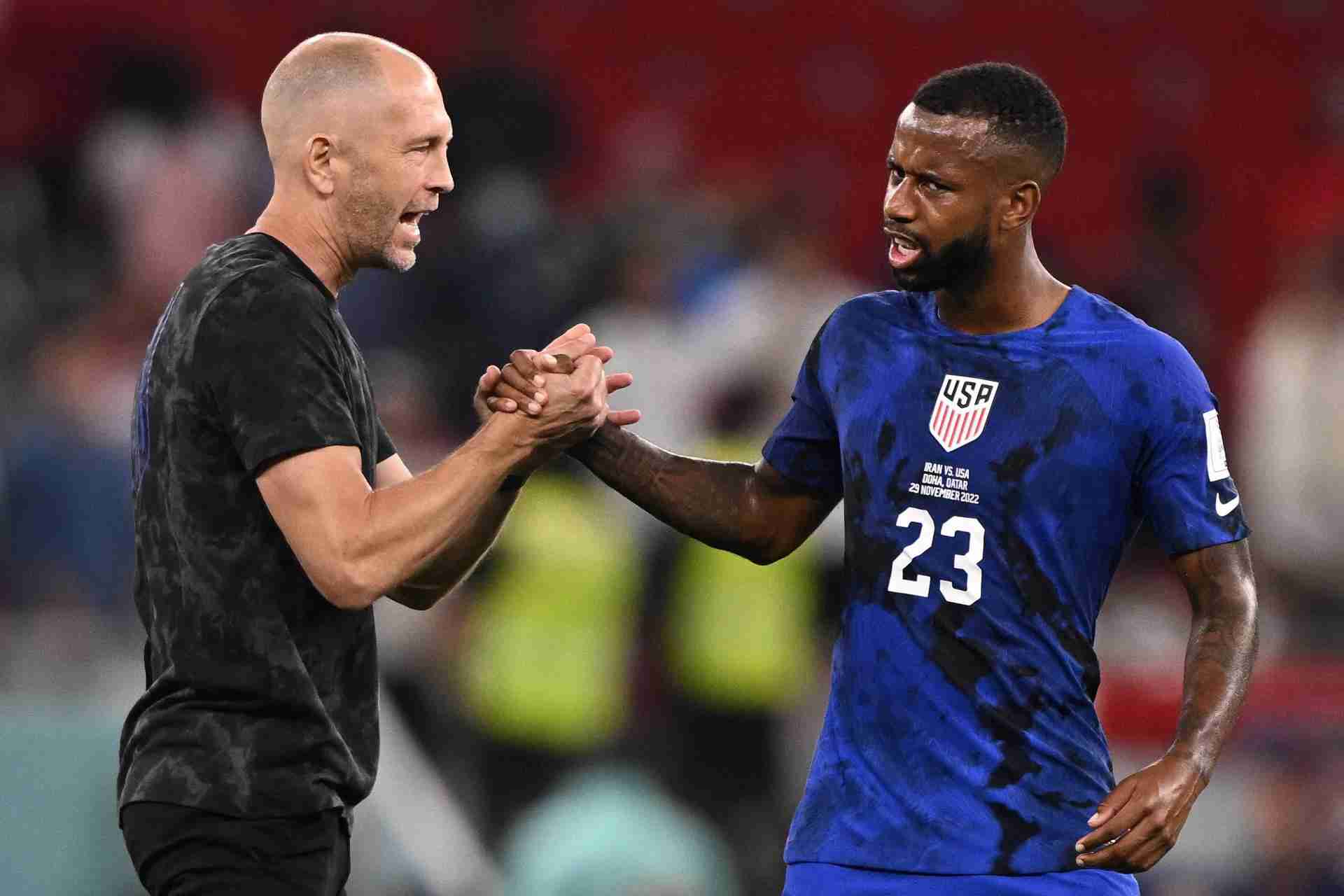 Gregg Berhalter and Kellyn Acosta clasping hands during the USMNT's 1-0 win over Iran at World Cup on November 29, 2022