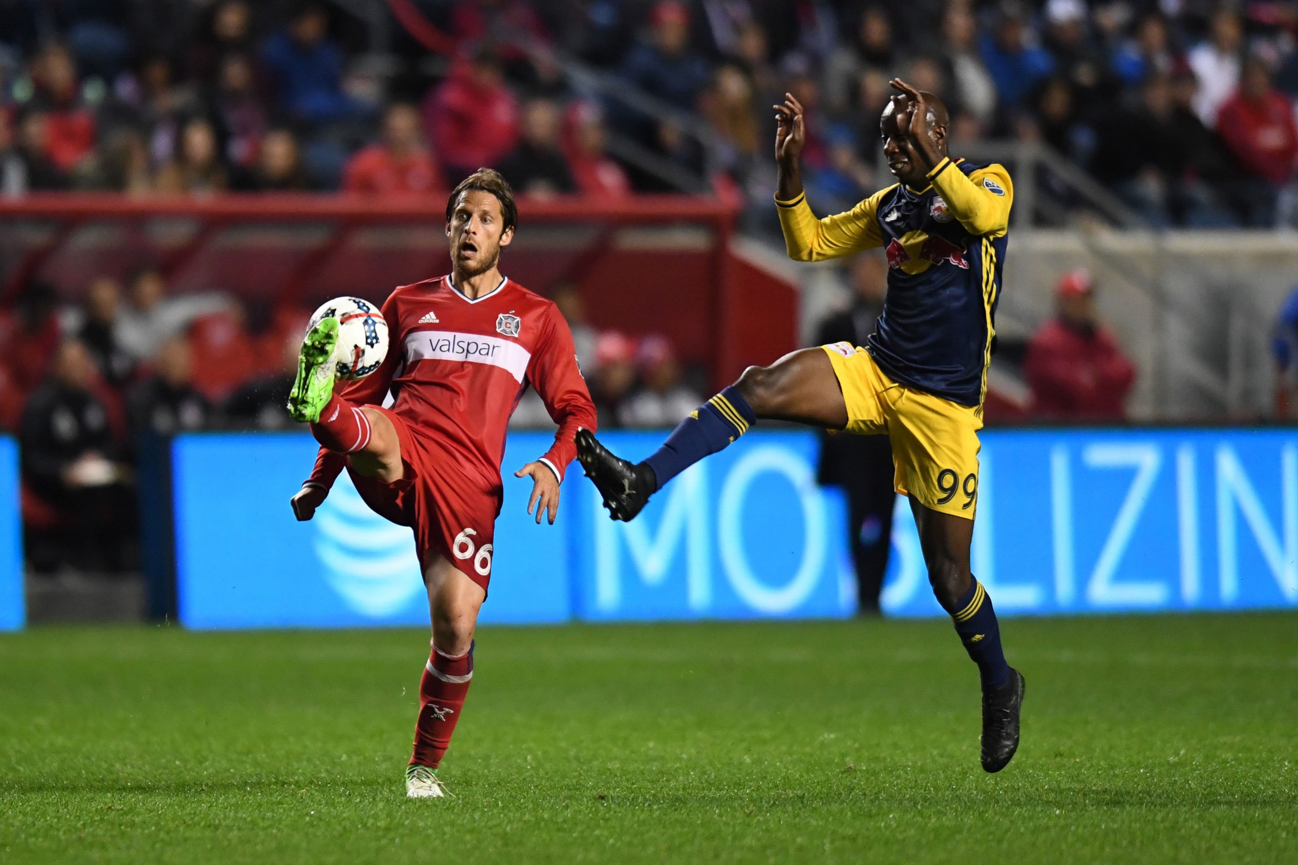 Oct 25, 2017; Chicago, IL, USA; Chicago Fire defender Joao Meira (66) kicks the ball against New York Red Bulls forward Bradley Wright-Phillips (99) during an Eastern Conference knockout round soccer game at Toyota Park. Red Bulls won 4-0. Mandatory Credit: Patrick Gorski-USA TODAY Sports