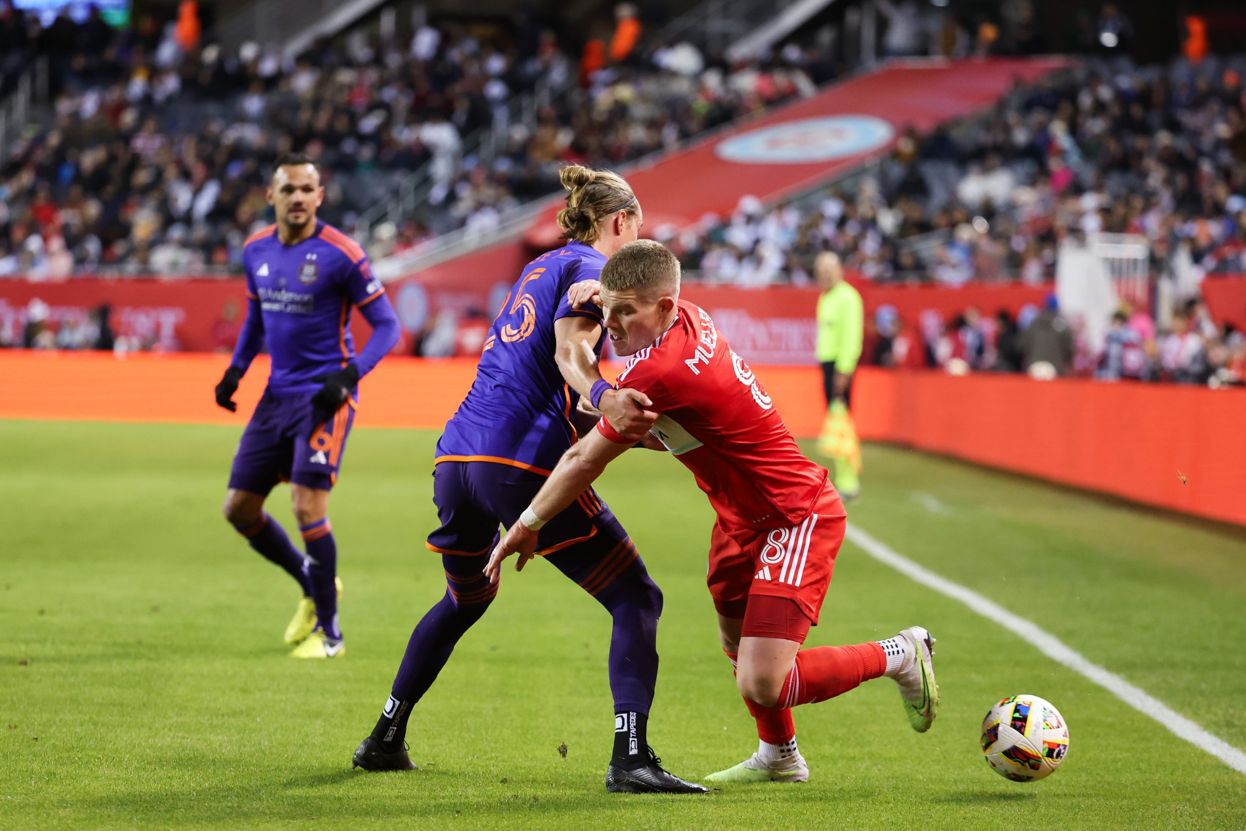 Apr 6, 2024; Chicago, Illinois, USA; Houston Dynamo FC midfielder Griffin Dorsey (25) challenges Chicago Fire FC forward Chris Mueller (8) for the ball during the first half at Soldier Field. Mandatory Credit: Mike Dinovo-USA TODAY Sports