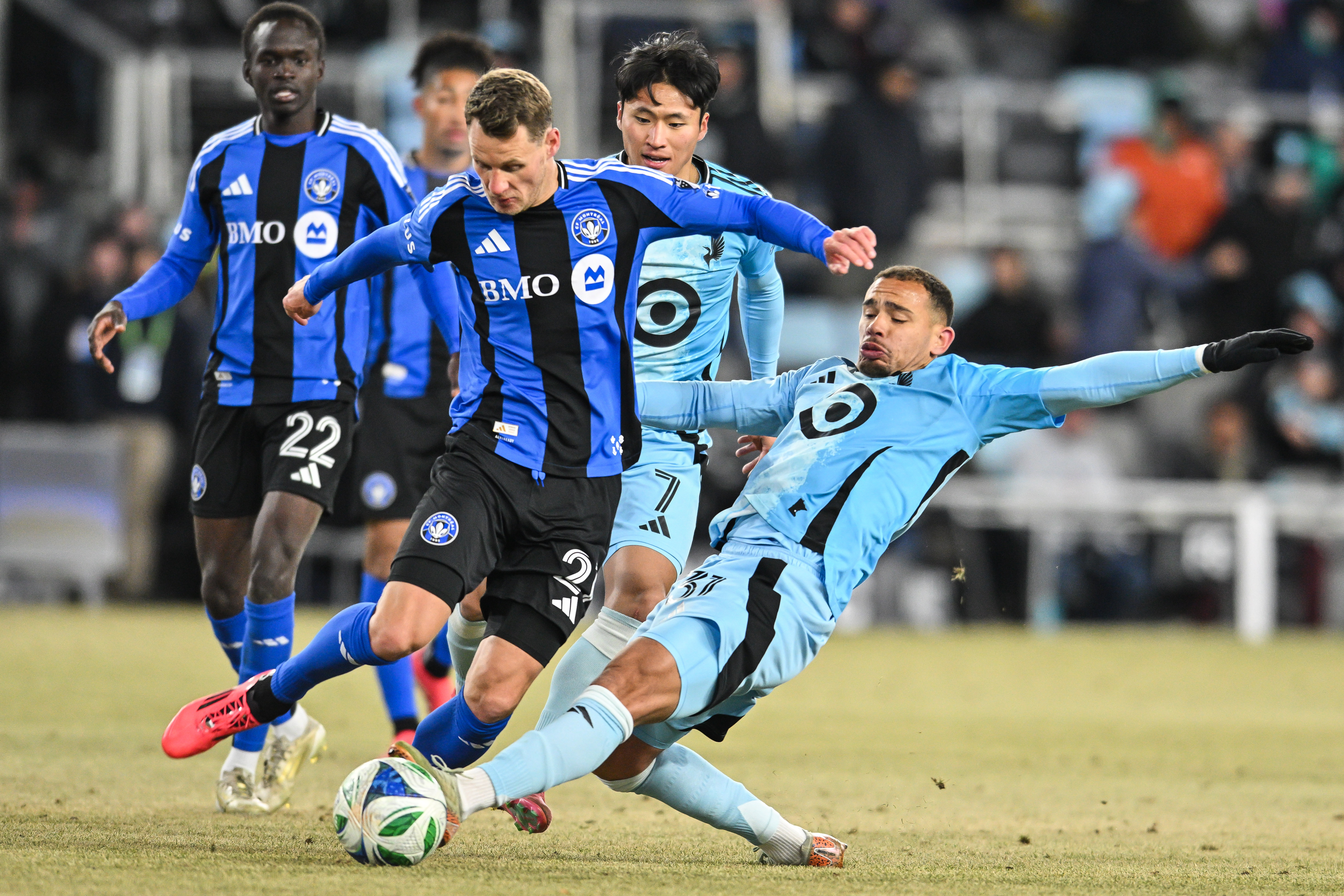 Mar 1, 2025; Saint Paul, Minnesota, USA; Minnesota United midfielder Hassani Dotson (31) and CF Montréal midfielder Fabian Herbers (21) battle for the ball during the second half at Allianz Field.