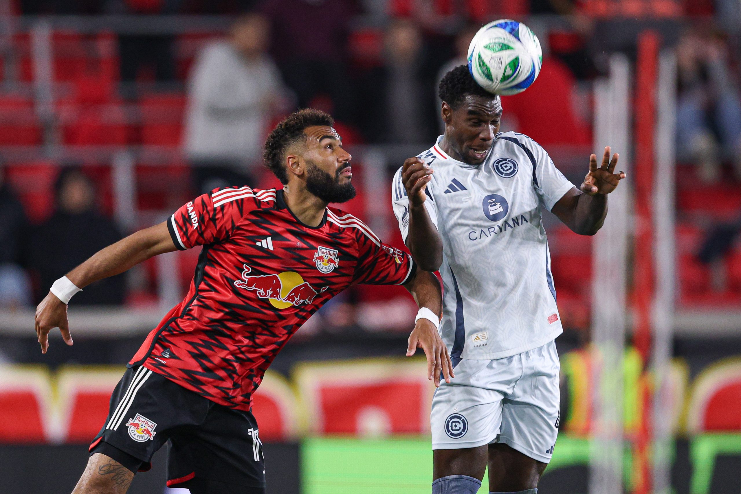Apr 5, 2025; Harrison, New Jersey, USA; Chicago Fire FC defender Carlos Teran (4) heads the ball against New York Red Bulls forward Eric Maxim Choupo-Moting (13) during the second half at Sports Illustrated Stadium.