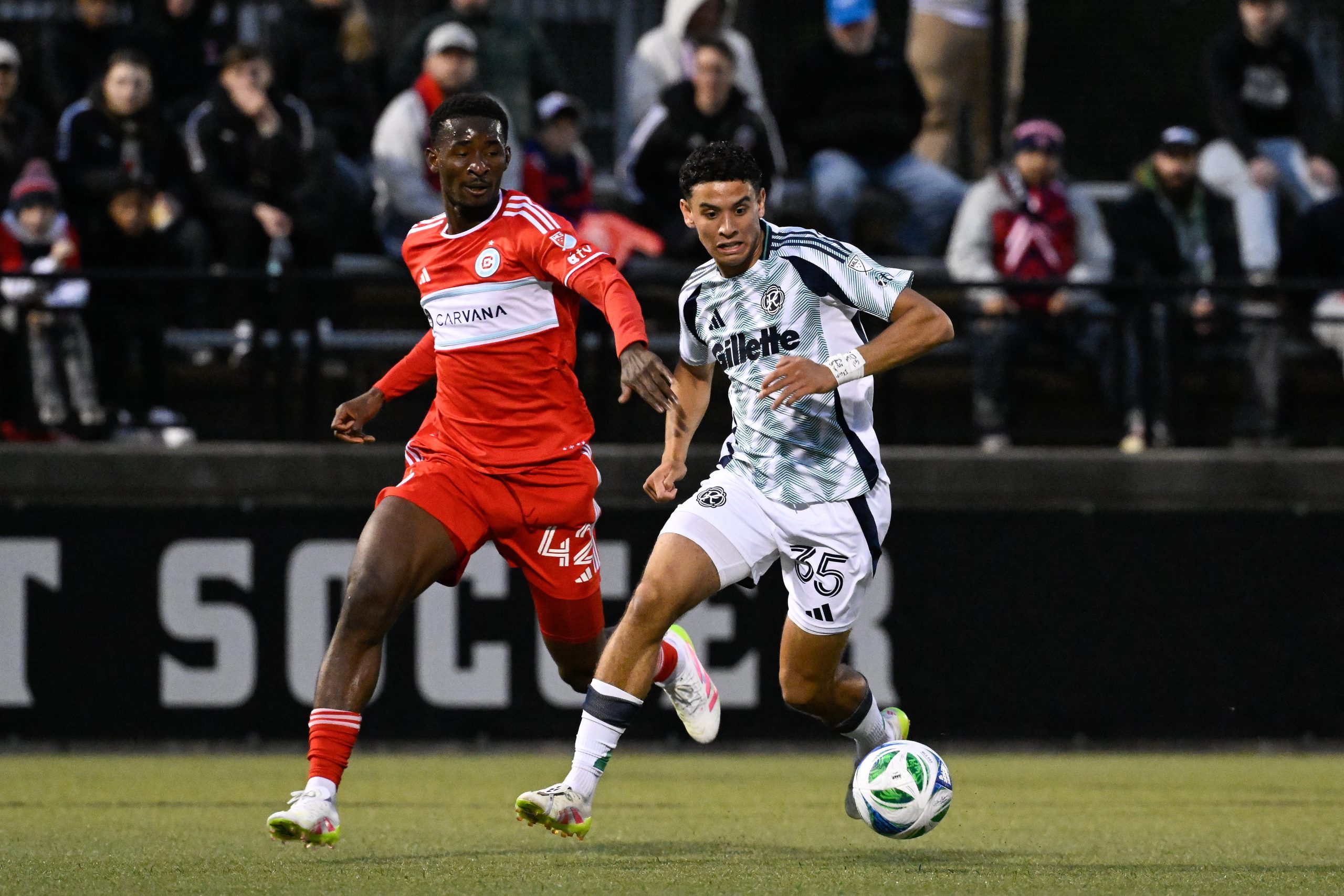 May 20, 2025; Providence, Rhode Island, USA; Chicago Fire midfielder Dje D'Avilla (42) and New England Revolution forward Christiano Oliveira (35) chase the ball during the first half at Chapey Field at Anderson Stadium. Mandatory Credit: Eric Canha-Imagn Images