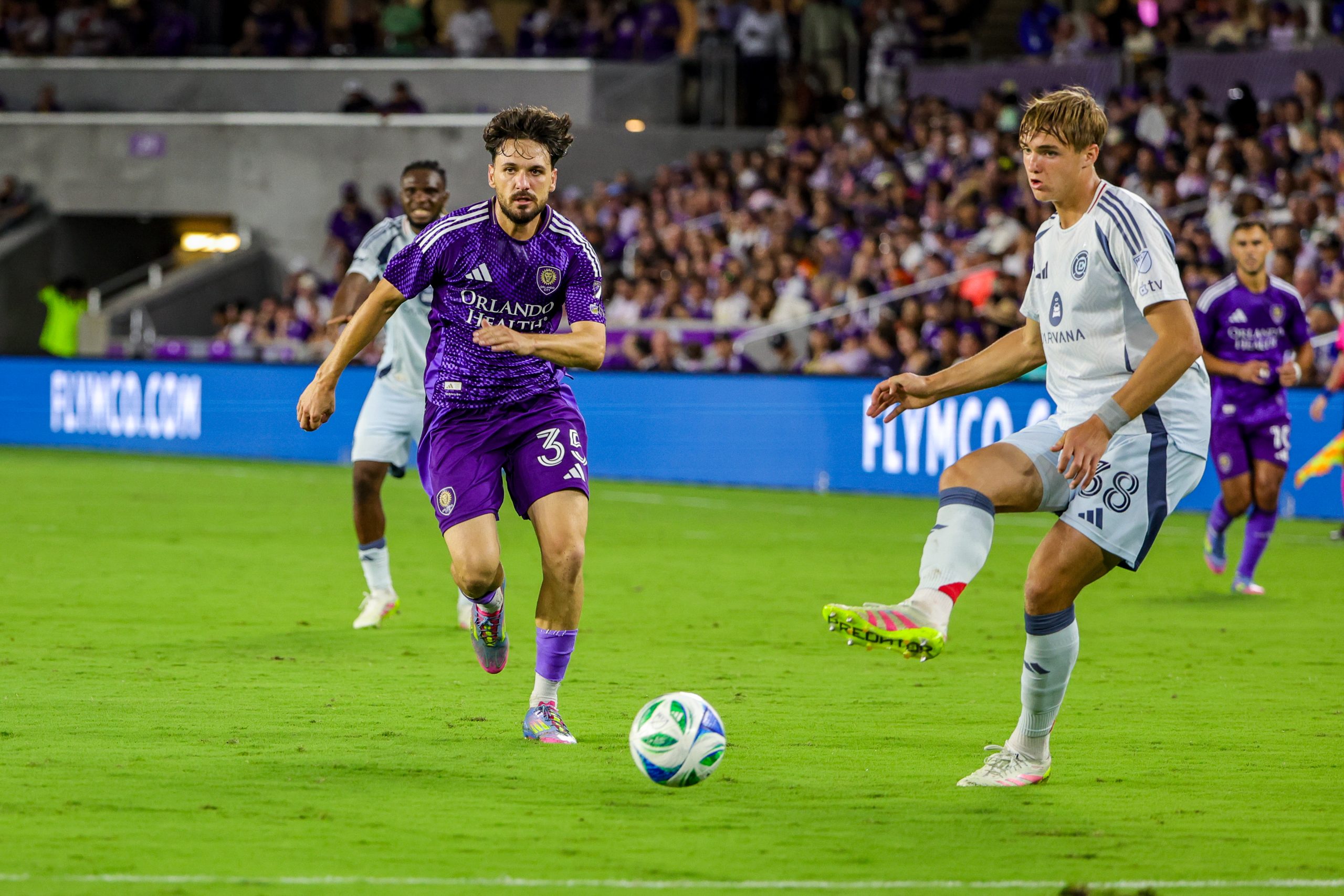 May 31, 2025; Orlando, Florida, USA; Chicago Fire defender Christopher Cupps (38) kicks the ball in front of Orlando City midfielder Joran Gerbet (35) during the second half at Inter&Co Stadium. Mandatory Credit: Mike Watters-Imagn Images