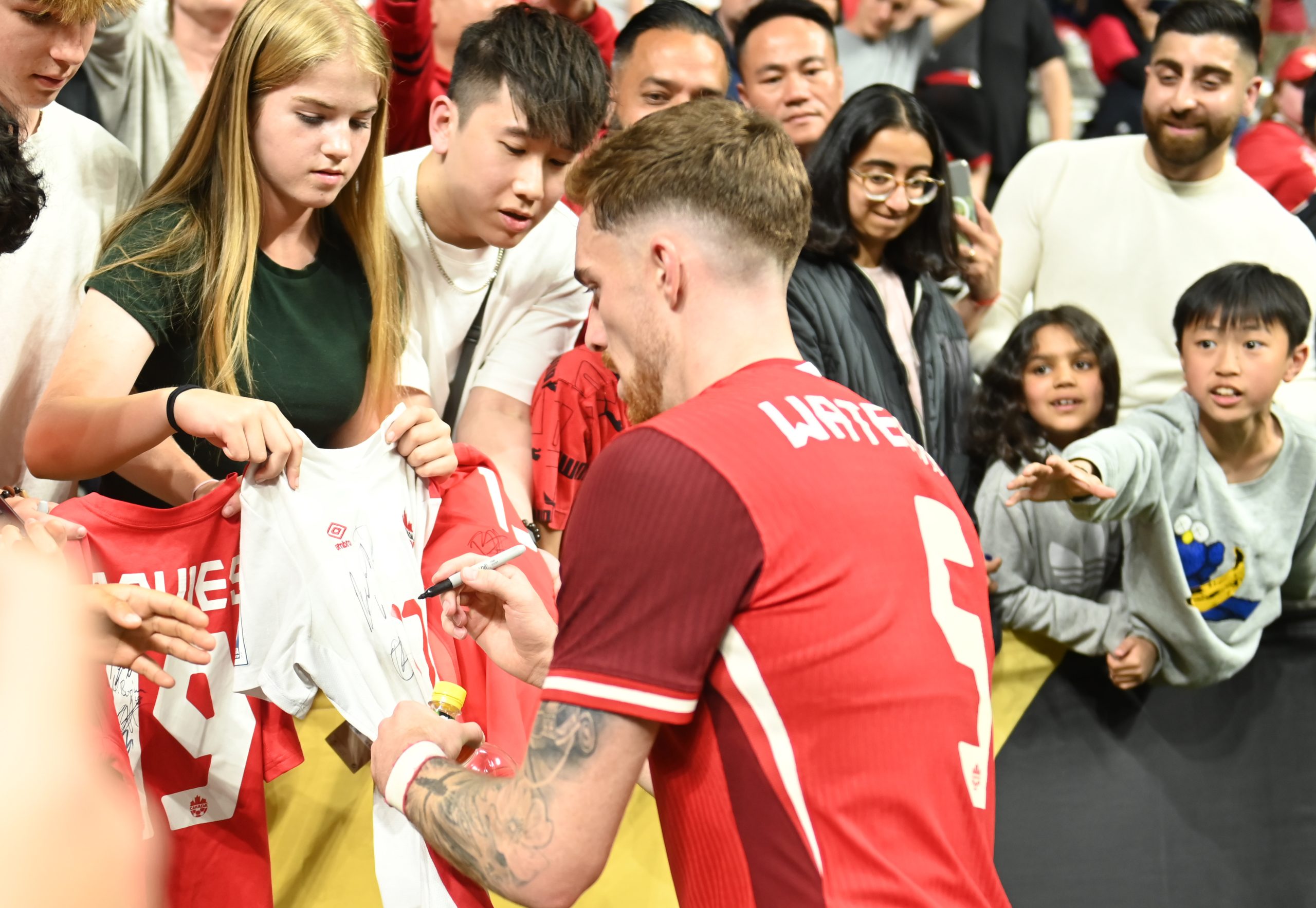 Jun 17, 2025; Vancouver, British Columbia, CAN; Canada defender Joel Waterman (5) signs autographs after a group stage match of the 2025 Gold Cup against Honduras at BC Place.