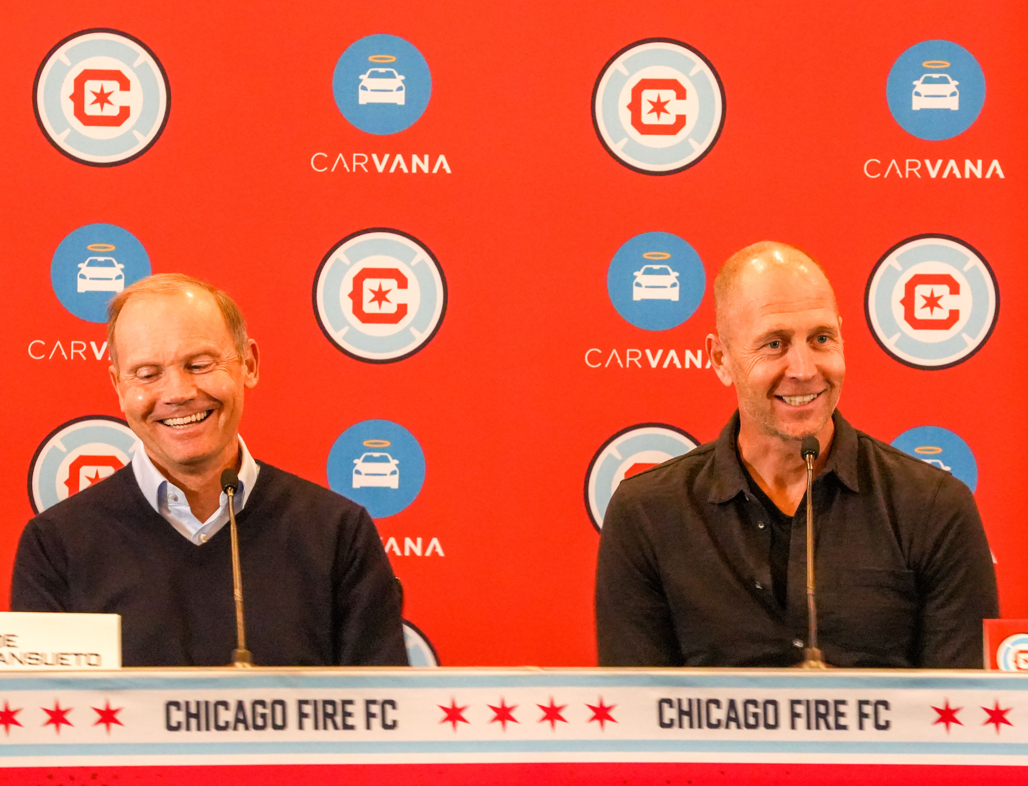 Joe Manuseto and Gregg Berhalter in front of a Chicago Fire logo backdrop