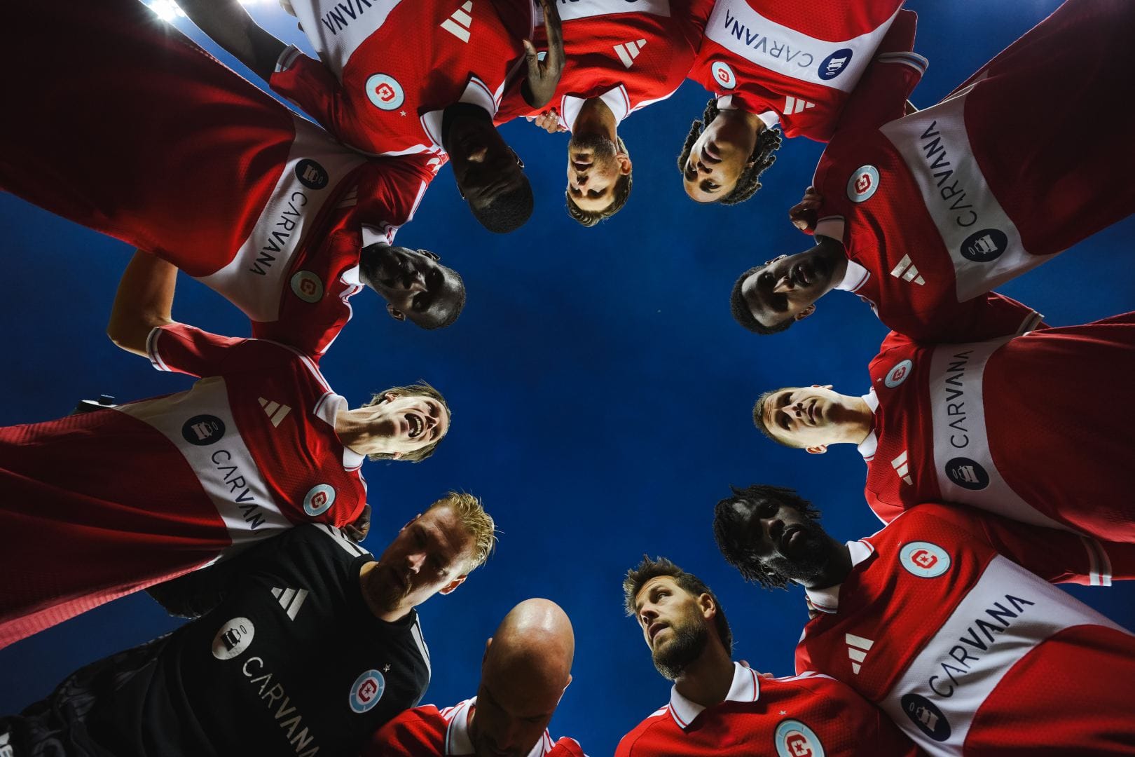 Chicago Fire FC players around a huddle, shot from below.