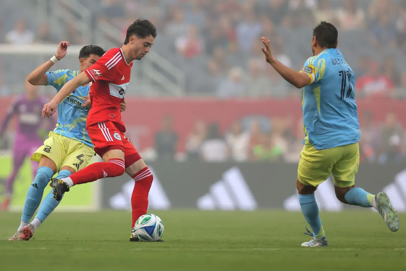 Chicago Fire FC player Brian Gutiérrez plays the ball as he's closed down by two Philadelphia Union defenders on June 25, 202