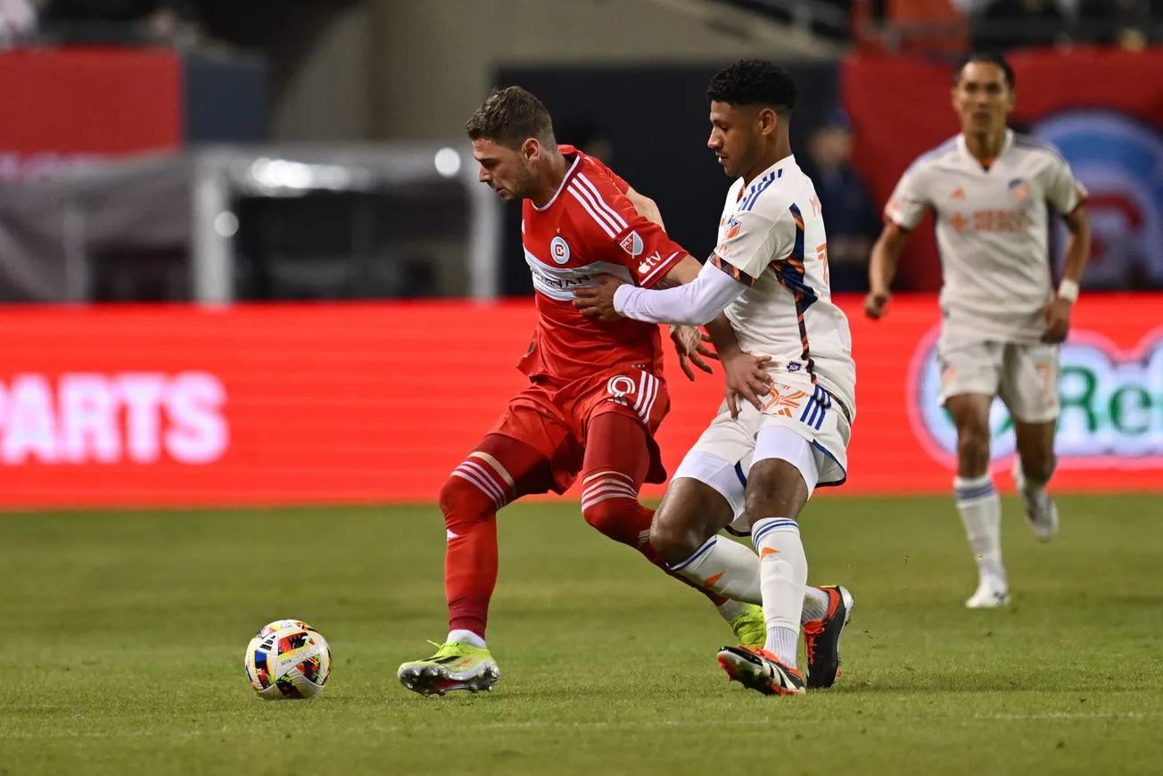 Chicago Fire's Hugo Cuypers and a FC Cincinnati player jostle for the ball during a soccer game at Soldier Field
