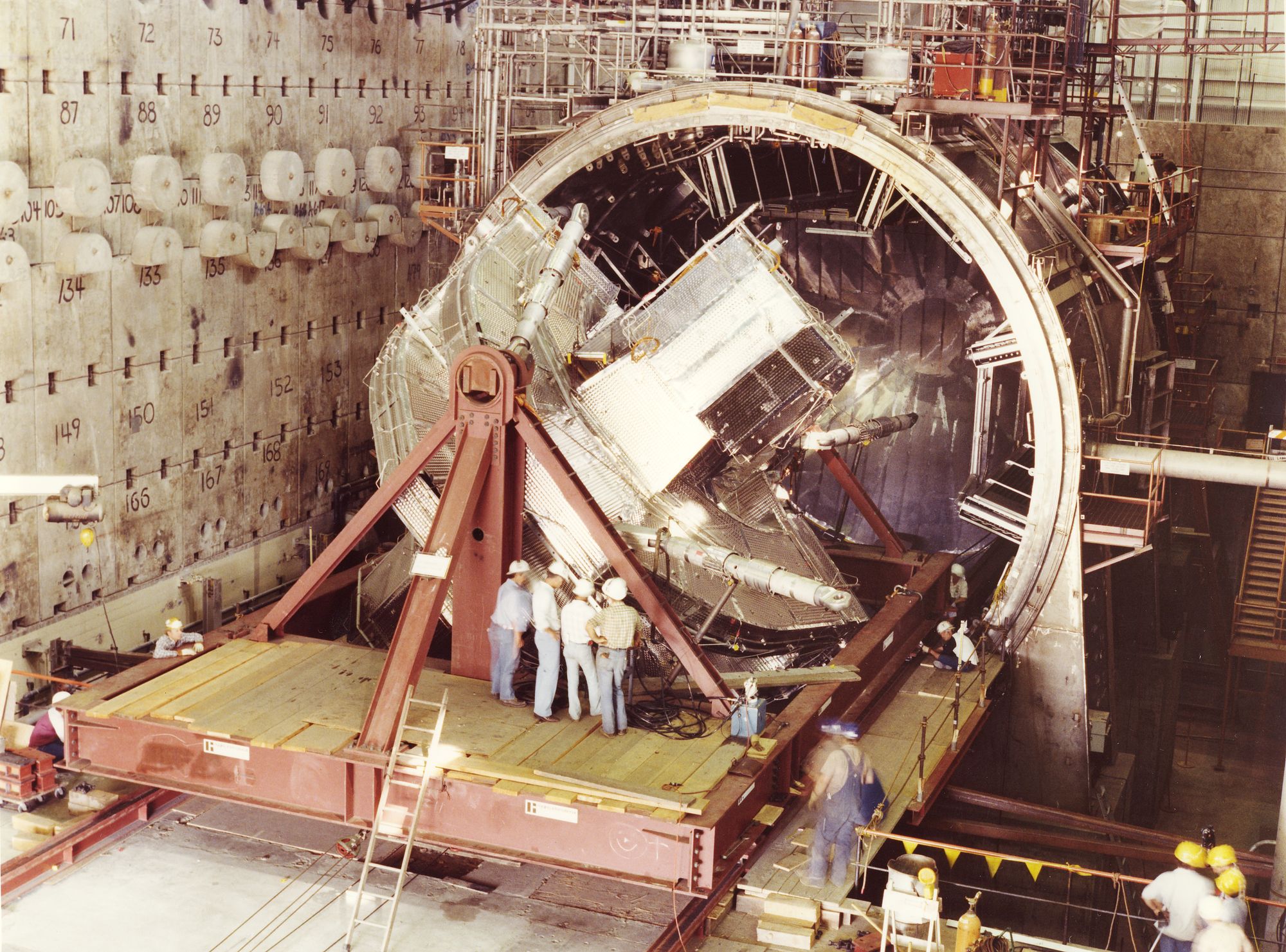 A massive magnet being installed into the partially built MFTF-B machine. 