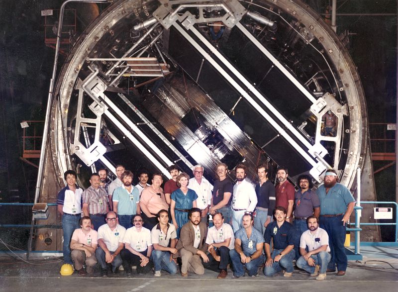 A crew stands before the partially installed magnet as part of the MFTF-B.