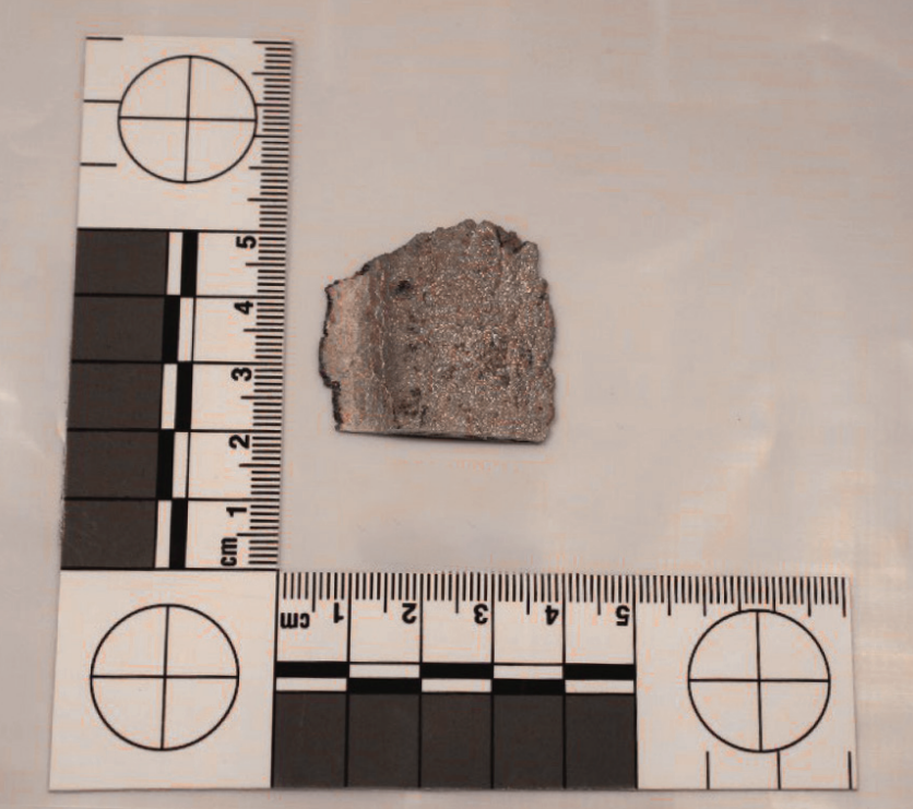 A specimen sample of a 3cm x 3cm silvery lump of metal photographed against a ruler.