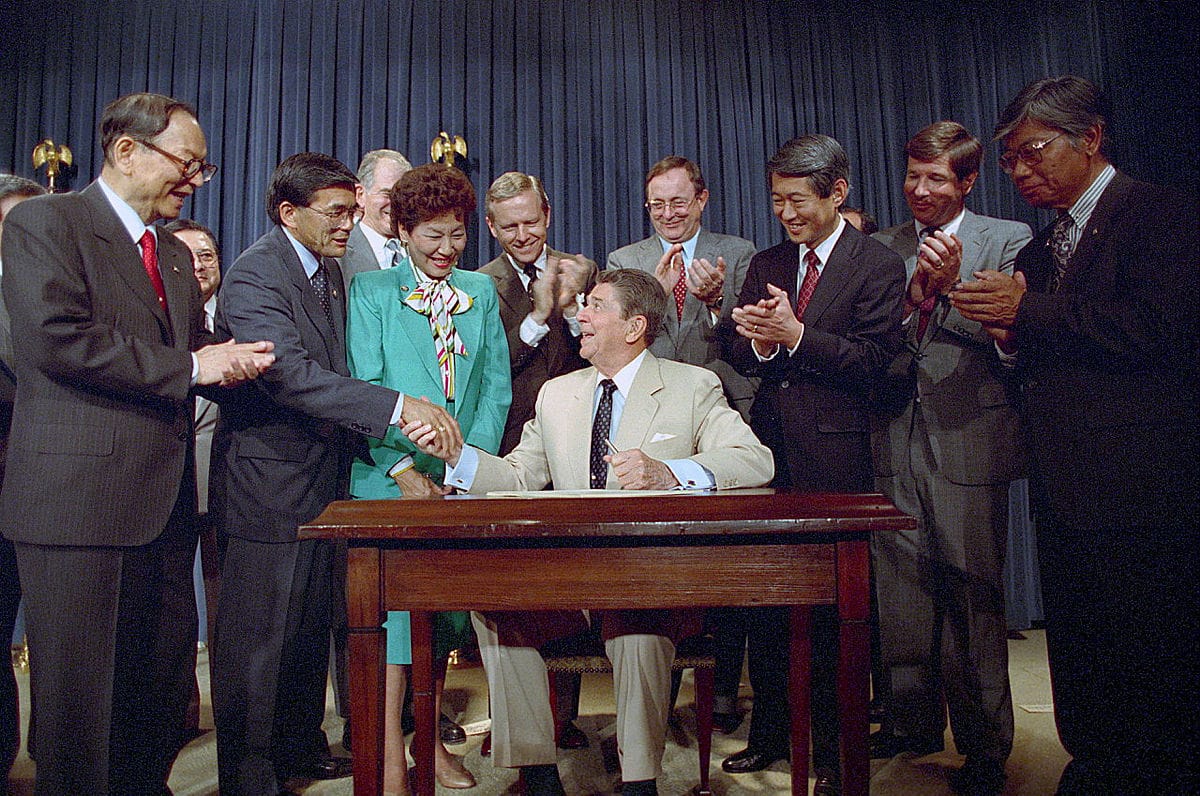 President Ronald Reagan Signs The Reparations Bill for Japanese Americans with Pete Wilson Spark Matsunaga, Norman Mineta, Robert Masui, and Bill Lowrey on August 10, 1988. Photo: Pete Souza / Ronald Reagan Presidential Library and Museum / NARA.