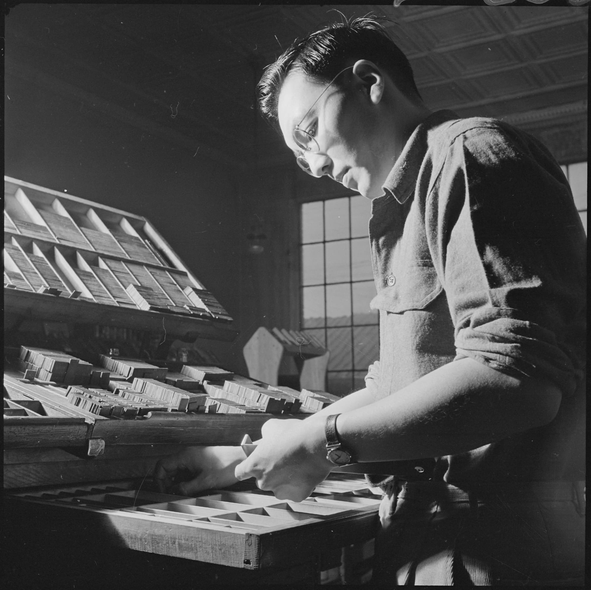"Heart Mountain Relocation Center, Heart Mountain, Wyoming. In the press room of the Cody Enterprise, Bill Hosokawa, Editor of the Sentinel, Heart Mountain Relocation Center newspaper, sets type for the final makeup of the weekly edition."  January 8, 1943. Photo: Tom Parker. https://catalog.archives.gov/id/539215