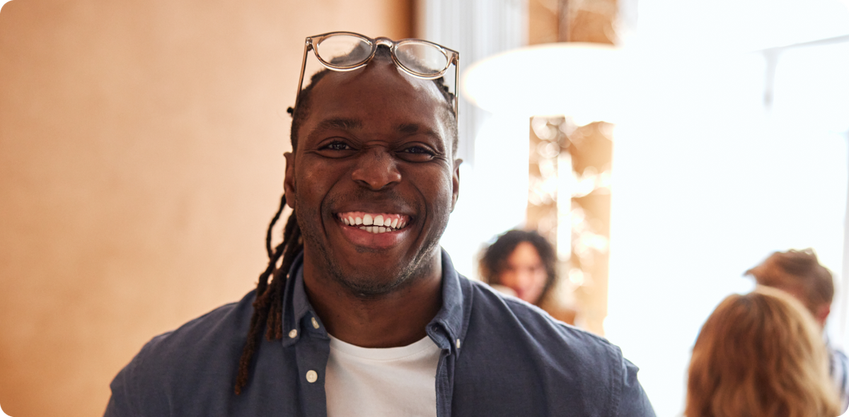 Smiling team member in casual office setting, representing a healthy approach to improving frontline performance