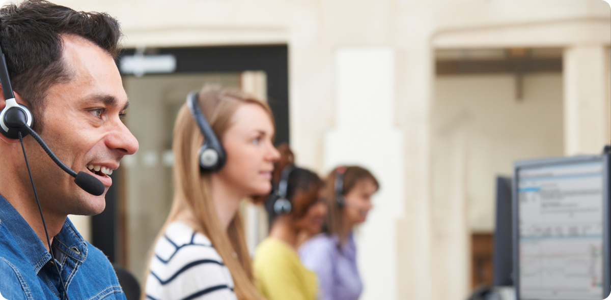 Call center employees wearing headsets, focused on computer screens, representing frontline workforce optimization in action